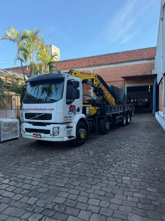 Caminhão munck Volvo da Guincho Sul estacionado em frente a galpão industrial